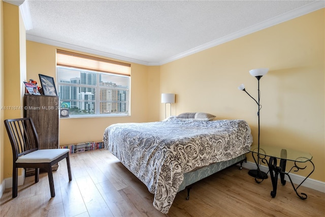 bedroom featuring hardwood / wood-style floors, a textured ceiling, and ornamental molding