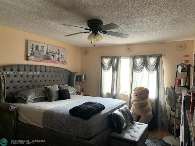 bedroom featuring hardwood / wood-style flooring, ceiling fan, and a textured ceiling