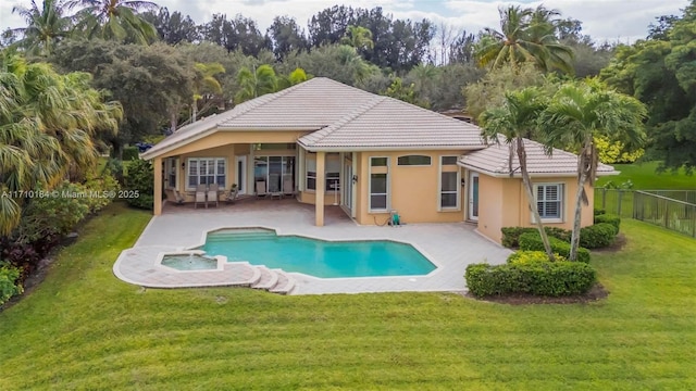 rear view of property with a fenced in pool, a patio area, and a yard