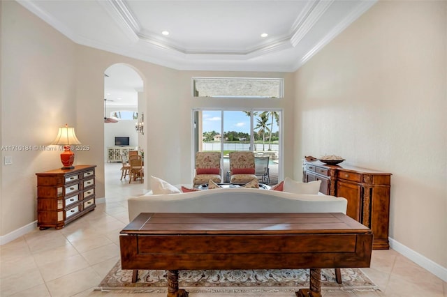 bedroom featuring light tile patterned floors, crown molding, and a tray ceiling