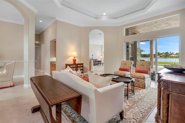 tiled living room with a tray ceiling and ornamental molding