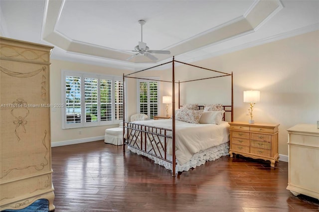 bedroom with a raised ceiling, ceiling fan, dark wood-type flooring, and crown molding