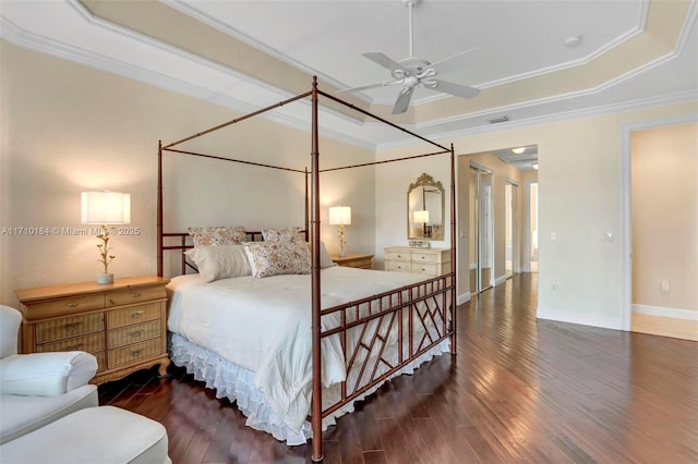 bedroom featuring a raised ceiling, ceiling fan, dark hardwood / wood-style flooring, and crown molding