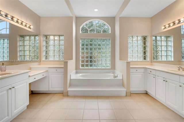 bathroom with a bathtub, vanity, and tile patterned flooring