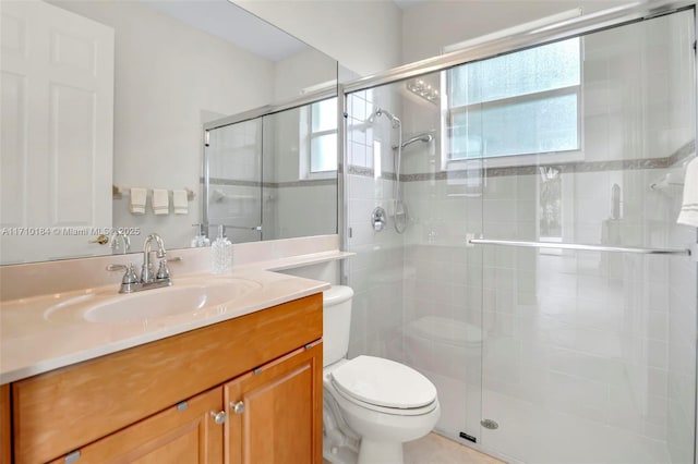 bathroom with a shower with door, vanity, and toilet