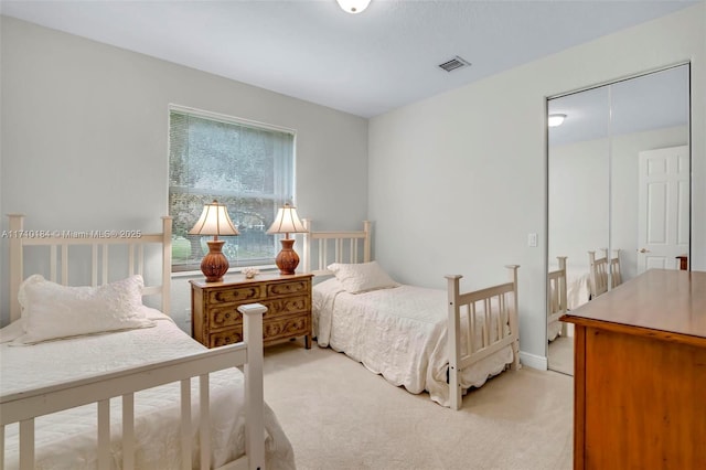 bedroom with light carpet and a closet