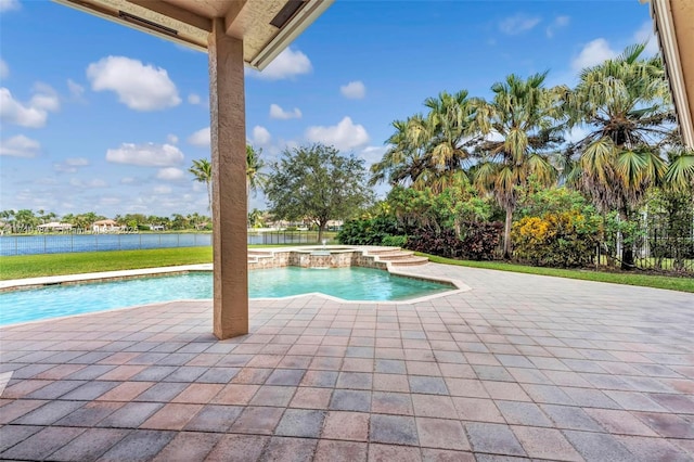 view of swimming pool featuring a water view and an in ground hot tub