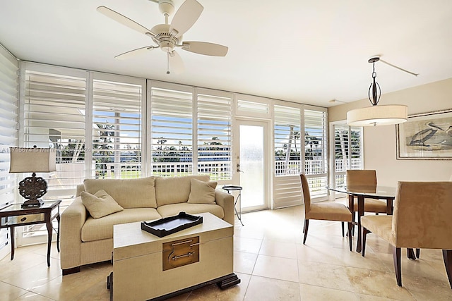 tiled living room featuring ceiling fan and a wall of windows