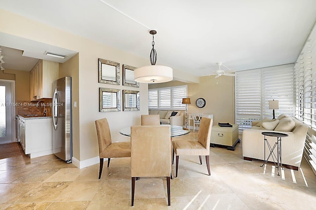 dining room featuring ceiling fan and sink