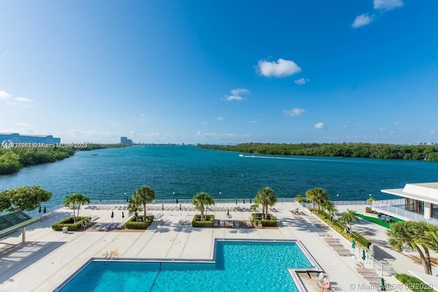 view of swimming pool with a water view and a patio