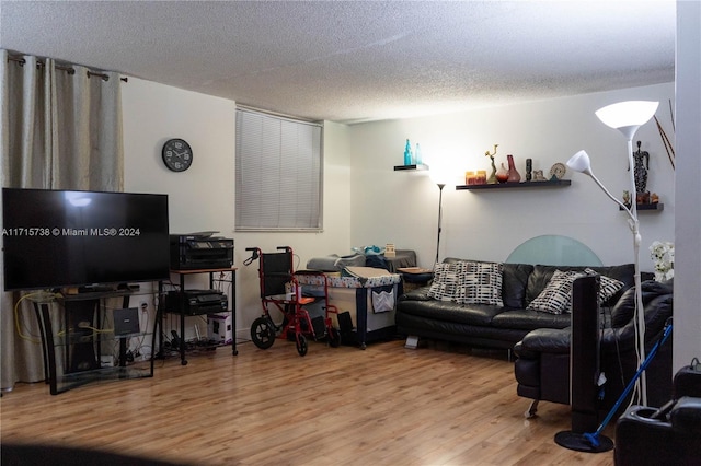 living room featuring wood-type flooring and a textured ceiling