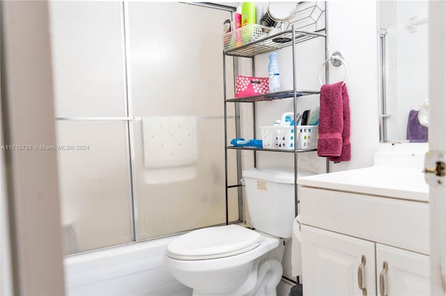 bathroom featuring vanity, toilet, and a shower with door