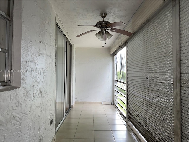 unfurnished sunroom featuring a ceiling fan