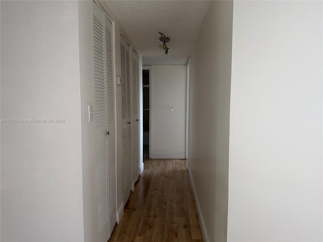 hall featuring baseboards and wood finished floors