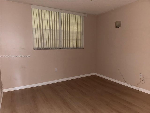 empty room with baseboards and wood finished floors