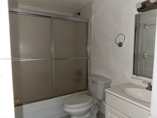 full bathroom with enclosed tub / shower combo, toilet, and vanity