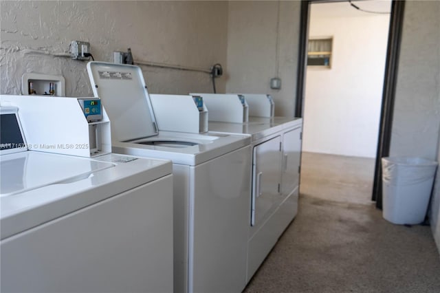 shared laundry area with light colored carpet, a textured wall, and separate washer and dryer