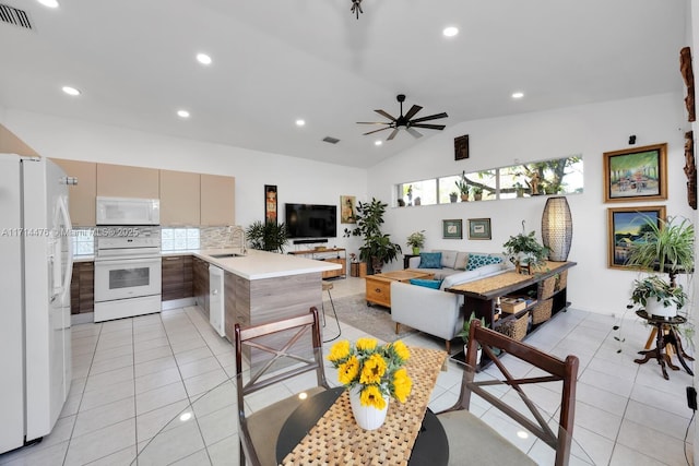 kitchen with sink, kitchen peninsula, vaulted ceiling, white appliances, and decorative backsplash