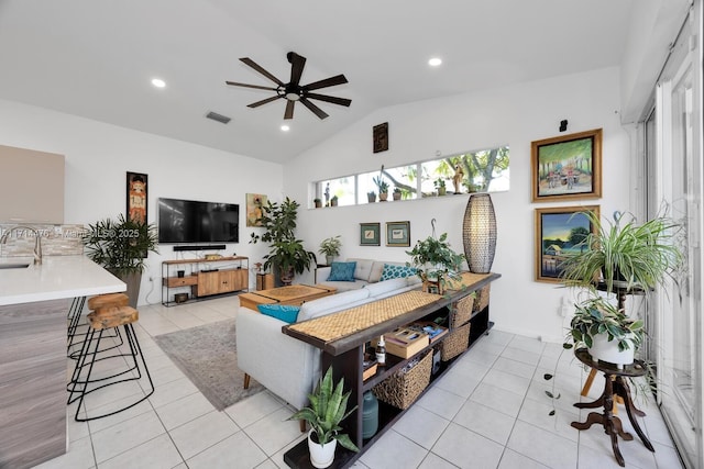 living room featuring light tile patterned floors, vaulted ceiling, ceiling fan, and sink