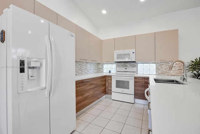 kitchen with sink, tasteful backsplash, white appliances, cream cabinetry, and light tile patterned flooring