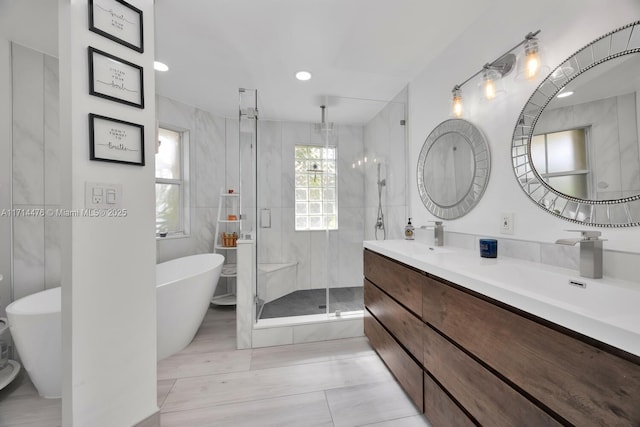 bathroom featuring separate shower and tub and vanity