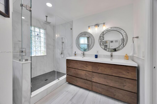 bathroom featuring a tile shower and vanity