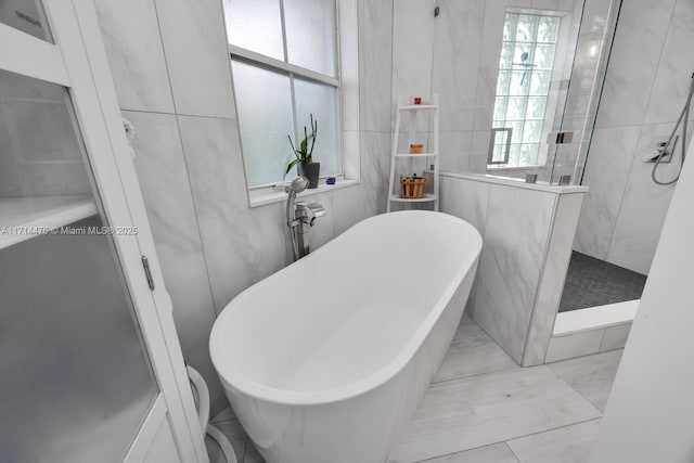 bathroom featuring independent shower and bath and tile walls