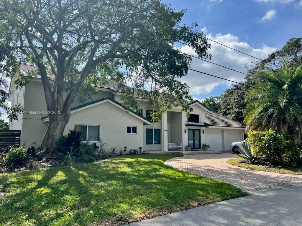 view of front of house featuring a garage and a front lawn