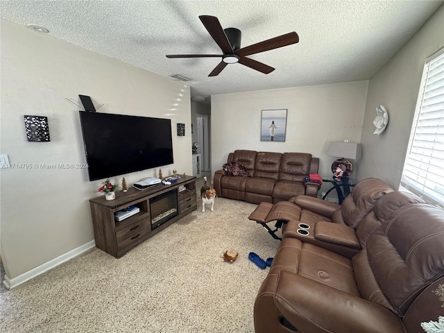 living room with a textured ceiling and ceiling fan