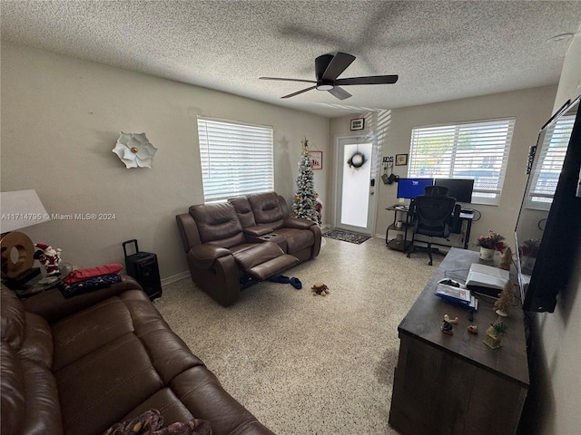 living room featuring a textured ceiling and ceiling fan