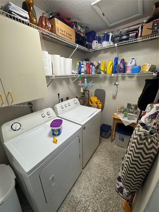 clothes washing area with cabinets, independent washer and dryer, and a textured ceiling