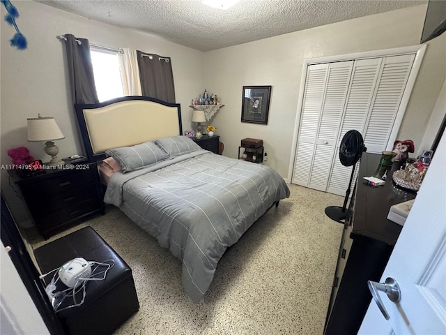 bedroom with a textured ceiling and a closet