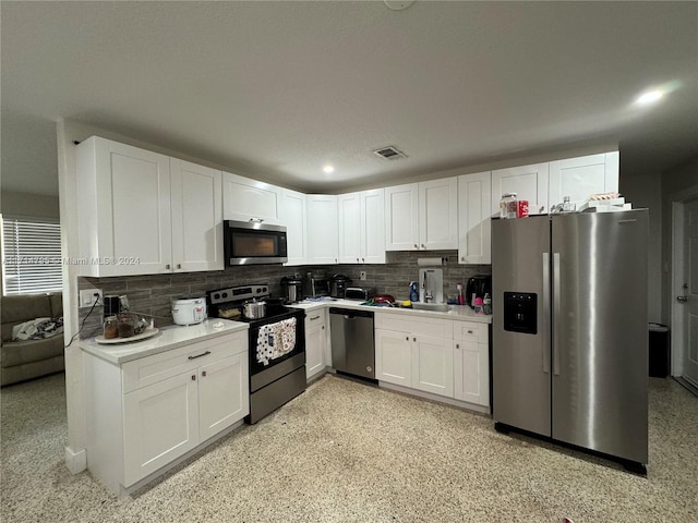 kitchen featuring decorative backsplash, white cabinetry, sink, and appliances with stainless steel finishes