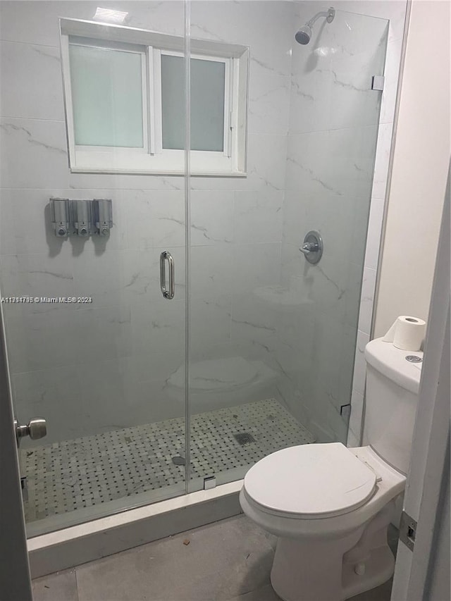 bathroom with tile patterned floors, toilet, and walk in shower