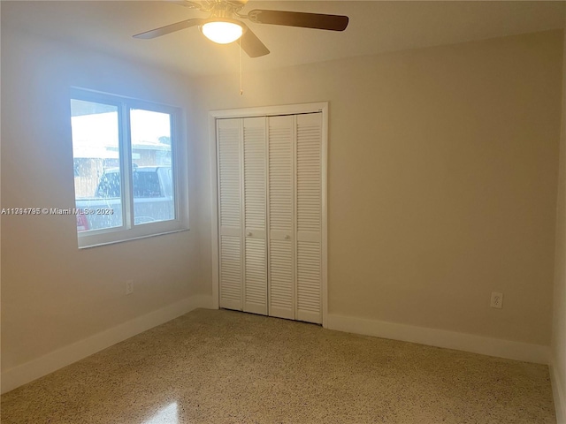 unfurnished bedroom with ceiling fan and a closet