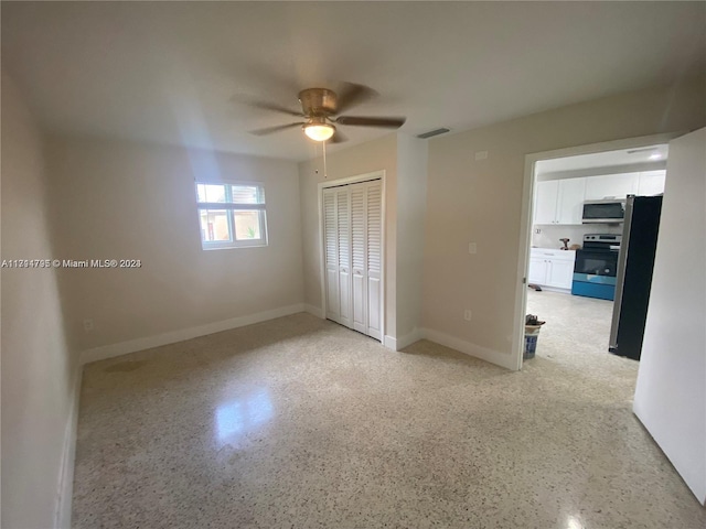 unfurnished bedroom with stainless steel fridge, a closet, and ceiling fan