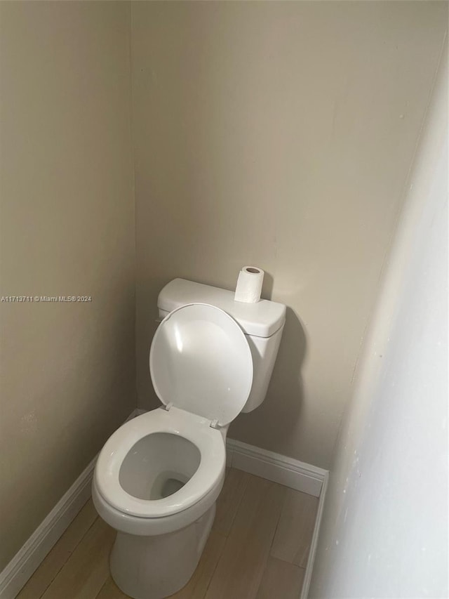 bathroom with toilet and wood-type flooring