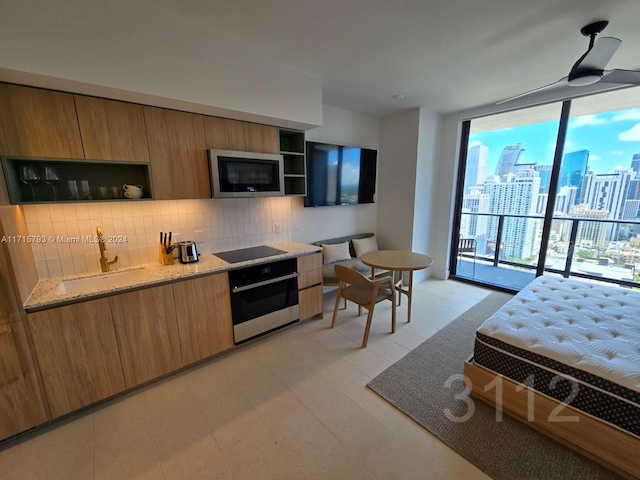 bedroom featuring access to outside, floor to ceiling windows, and sink