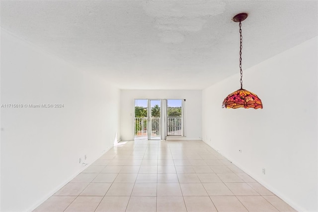 tiled empty room with a textured ceiling