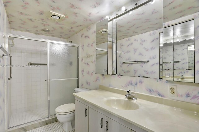 bathroom featuring toilet, vanity, tile patterned floors, and an enclosed shower