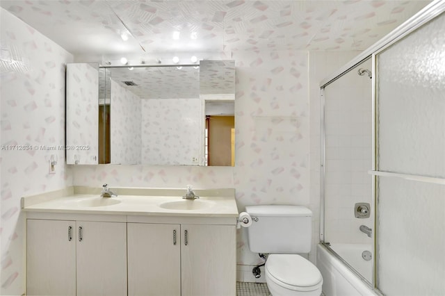 full bathroom with vanity, toilet, and bath / shower combo with glass door