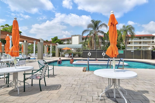 view of swimming pool with a patio and a pergola