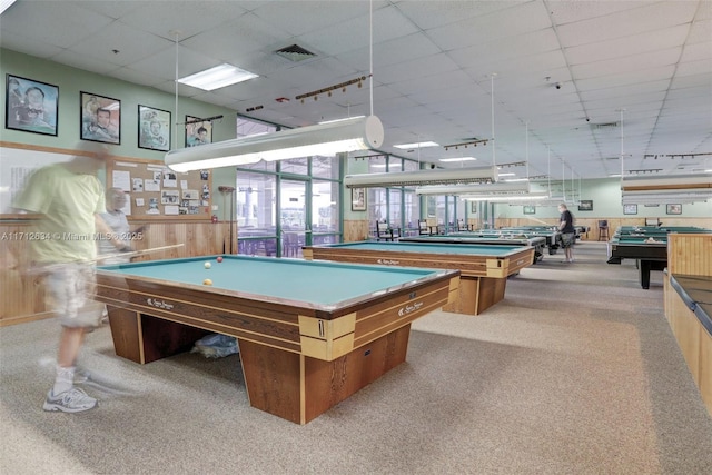 recreation room featuring a paneled ceiling, wooden walls, light carpet, and billiards