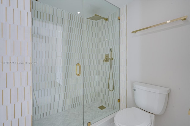 bathroom with a shower with shower door and toilet