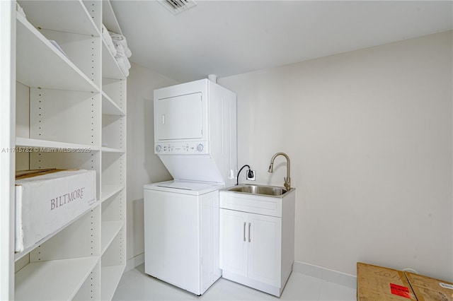 laundry area with stacked washing maching and dryer and sink