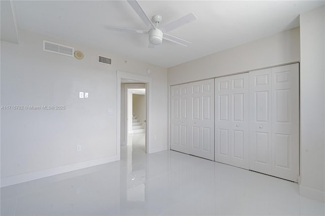 unfurnished bedroom with ceiling fan, light tile patterned flooring, and a closet