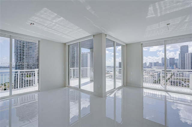 tiled spare room featuring a wall of windows