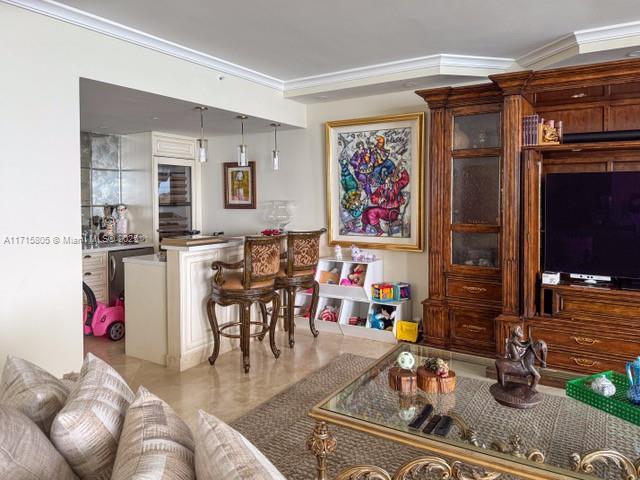 tiled living room with bar and ornamental molding