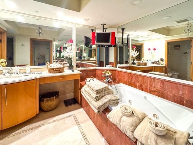 bathroom with vanity, tiled bath, and an inviting chandelier