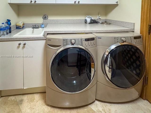 washroom with washing machine and clothes dryer, sink, and cabinets